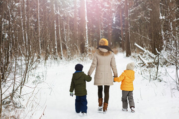 Naklejka premium Happy family playing and laughing in winter outdoors in the snow. City park winter day.