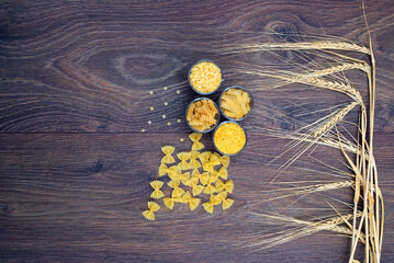 Various pasta on spoons over stone background. Top view with copy space