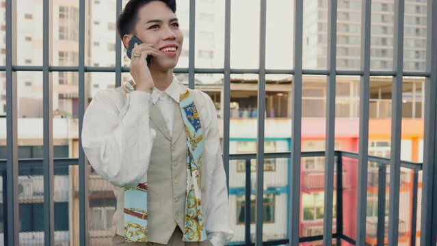 Transgender men having fun doing talking on the phone with friend at the rooftop.