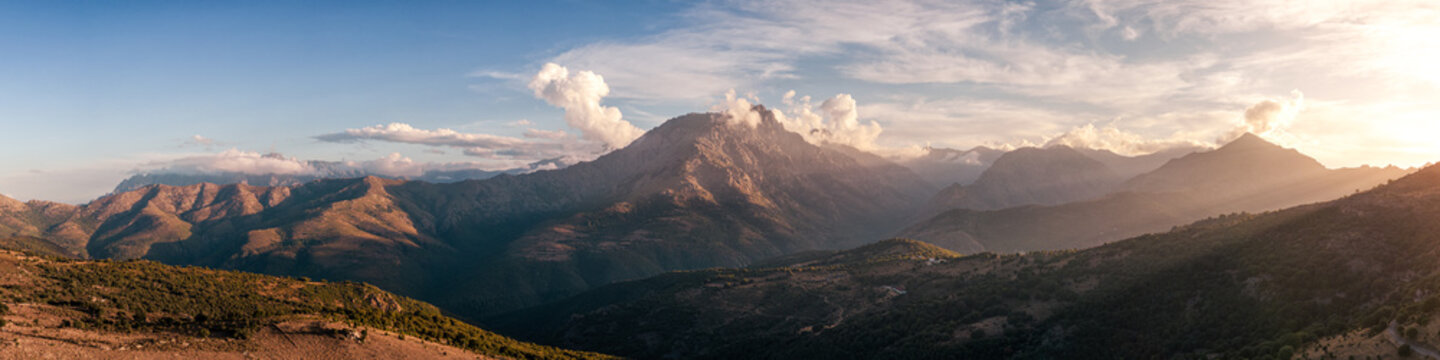 Panoramic view of evening sunshine on the 2389 metre peak of Monte Padro and surrounding mountains in the Balagne region of Corsica