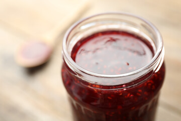 Homemade delicious raspberry jam on table, closeup