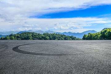 Empty asphalt road and green forest with mountain scenery