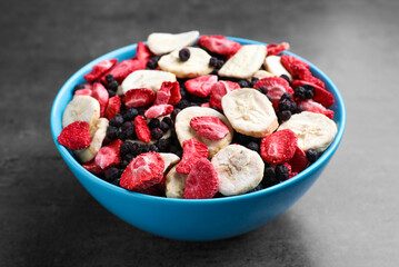 Bowl of dried fruits on grey table, closeup