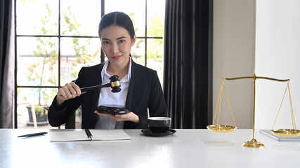 Female judge or lawyer holding a gavel and looking confidently to camera. Lawyer, justice and law...