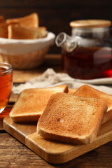 Slices of tasty toasted bread on wooden table