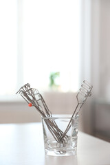 Set of different logopedic probes in holder on light table. Speech therapist's tools