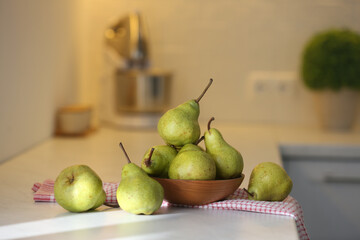 Fresh ripe pears on white countertop in kitchen