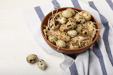 Quail eggs in a bowl on a white texture background. Whole and broken quail eggs. Natural products....