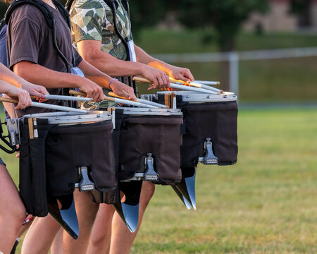 a section of a marching band drum line rehearsing