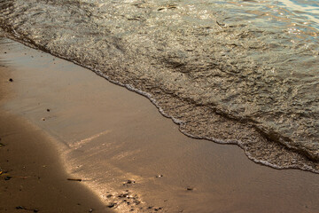 穏やかに波が打ち寄せる夕方の砂浜
