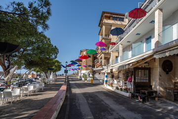 The waterfront of Marina di Camerota with colorful floating umbrellas, a popular summer tourist...