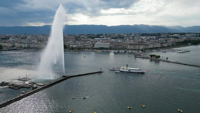 Drone point of view on Geneva Lake, jet fontain and big tourist ship with swiss flag passin by