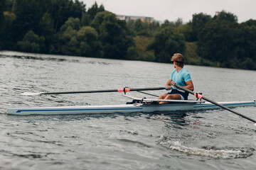 Sportsman single scull man rower rowing on boat. © primipil