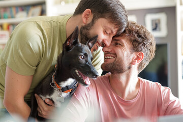 Close up of happy gay couple with dog adopted at animal shelter - Portrait of young man with pet...