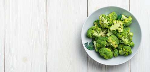 A plate of broccoli on a white wooden background with space to copy. Healthy food. Top view, horizontal