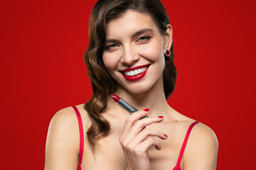 Elegant woman with red lips holding lipstick in hand