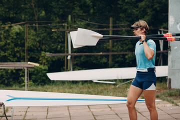 Sportsman single scull man rower prepare to competition with boat. © primipil