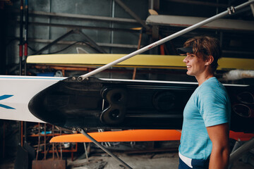 Sportsman single scull man rower prepare to competition with boat.