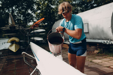 Sportsman single scull man rower prepare to competition with boat.