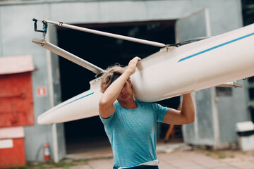 Sportsman single scull man rower carrying boat to competition © primipil