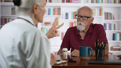 Female doctor shows X-Ray film to an elderly man old patient, provide professional medicare health insurance.