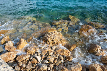Gentle waves splashing the rocky shore of Mimice, Croatia