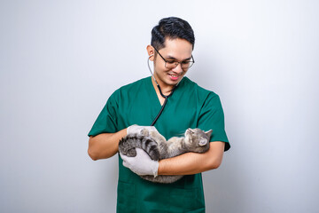 Young asian vet wearing scrubs and glasses examine pet cat