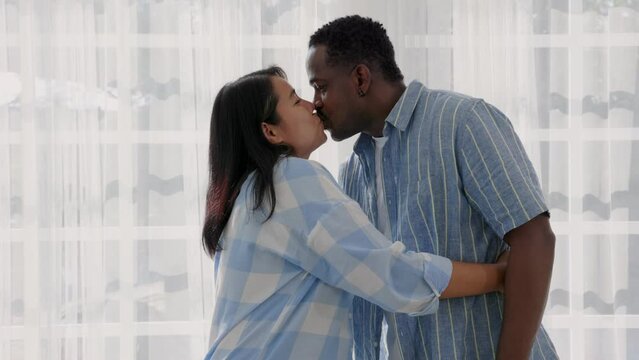 interracial couple kissing in the home on Valentine's Day.