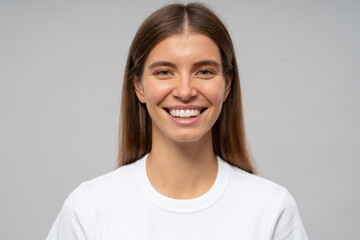 Fototapeta premium Headshot of happy woman with healthy white toothy smile on gray studio background
