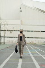 Walking and smiling under her face mask