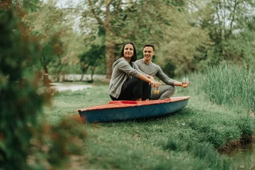 Foto op Canvas Couple sitting on a red kayak © qunica.com