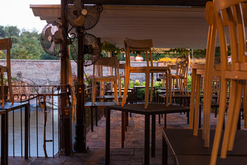 Fototapeta na wymiar Chairs over tables at tourist restaurant, economic crisis concept