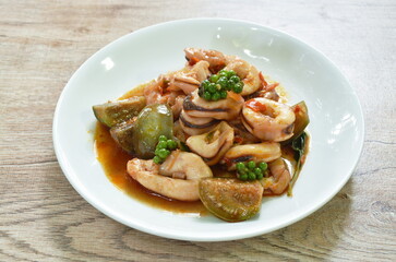 spicy chili fried squid with eggplant and fresh pepper topping basil leaf on plate