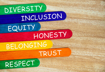 Diversity, inclusion, equality, honesty, belonging, trust and respect text on colorful wooden stick...