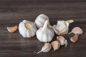 White garlic bulbs (Allium sativum) on gray wooden background. 