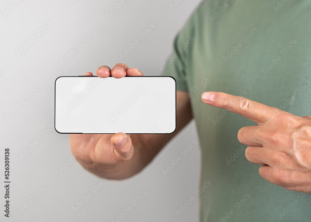 Poster man forefinger pointing to display of phone mockup. smartphone with white template. male showing mob