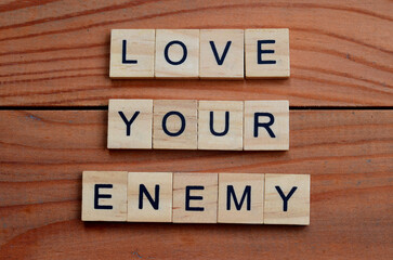 Love your enemy text on wooden square, religion motivation quotes