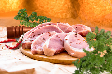 Fresh raw pork chops on a cutting board.  Arrangement  on the wrapping paper