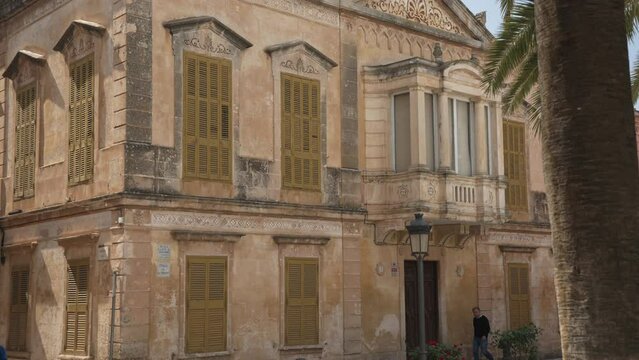 Palm tree and ornate old buildings in Placa D'Alfons lll Conqueridor, Ciutadella, Menorca, Balearic Islands