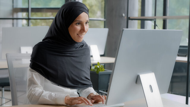 Excited joyful businesswoman sitting at workplace in office receiving email on computer reading excellent news enthusiastic happy woman manager rejoicing in victory celebrating success good result
