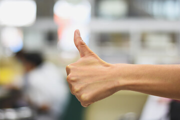 Close-up of woman's hand thumbs up