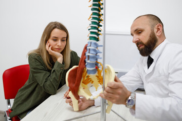 Orthopedic doctor talks about problems with the spine using a model as an example
