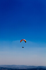 Fototapeta na wymiar A person paragliding across the sky.