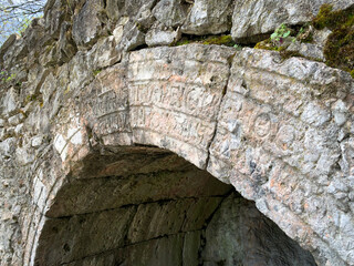 An ancient stone arch with engraved inscriptions in
The Sanctuary of the Nymphs and Aphrodite...