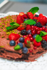 Delicious vegetarian chocolate cake with berries and pistachio  - 526317394