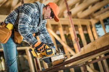 Carpenter Planing Wood Plank at the Construction Site