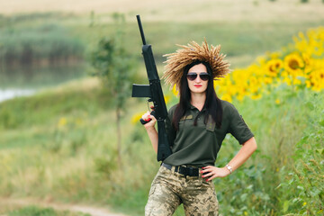 Female soldier in military uniform. A girl in a military uniform with a weapon. Ukrainian woman in a wreath