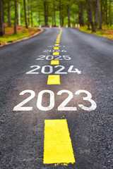 New year of 2023 2024 2025 and 2027 on asphalt road surface with marking lines. Happy new year concept and keep moving idea