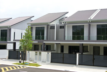 SELANGOR, MALAYSIA - JUNE 18, 2022: New double-story terrace house under construction in Malaysia. This house has a wide front porch and is fenced. Has basic facilities.