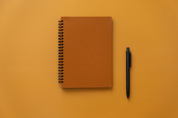 Orange craft notebook on a spring on an orange background